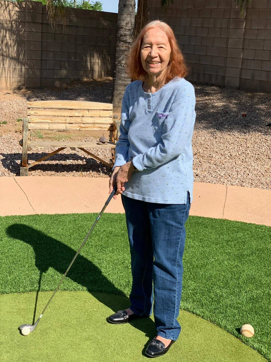 A resident holding a golf club, staying active