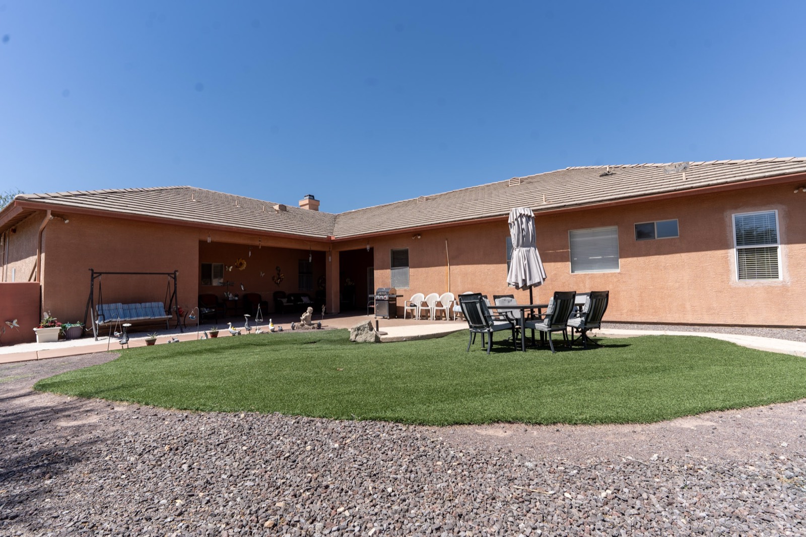 The backyard garden and green lawn with patio seating at Grace Hill Ranch